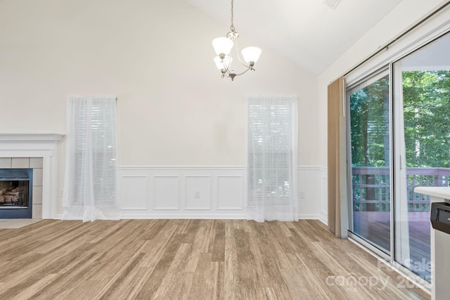 131 Canopy Ct, Mooresville, NC 28115 - unfurnished dining area featuring wood finished floors, a chandelier, wainscoting, a fireplace, and high vaulted ceiling