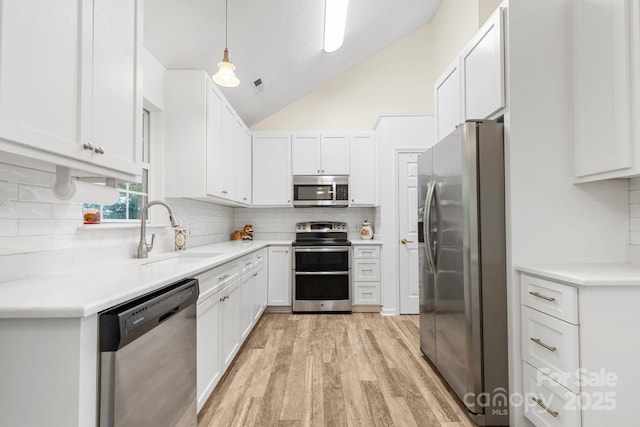 131 Canopy Ct, Mooresville, NC 28115 - kitchen featuring stainless steel appliances, light wood-type flooring, tasteful backsplash, white cabinets, and lofted ceiling