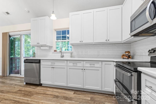 131 Canopy Ct, Mooresville, NC 28115 - kitchen with appliances with stainless steel finishes, light countertops, backsplash, and white cabinetry