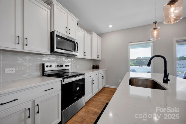 1315 Elizabeth Ave, Kannapolis, NC 28083 - kitchen featuring stainless steel appliances, decorative backsplash, white cabinets, hanging light fixtures, and recessed lighting
