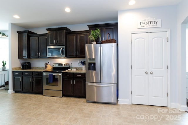 2405 Emma Grace Ln, Rock Hill, SC 29732 - kitchen with appliances with stainless steel finishes, light stone countertops, recessed lighting, and dark brown cabinetry