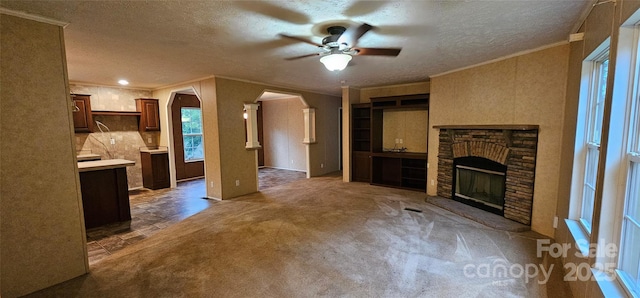 6220 Dekalb Dr, Connelly Springs, NC 28612 - unfurnished living room with crown molding, a ceiling fan, arched walkways, a textured ceiling, and plenty of natural light