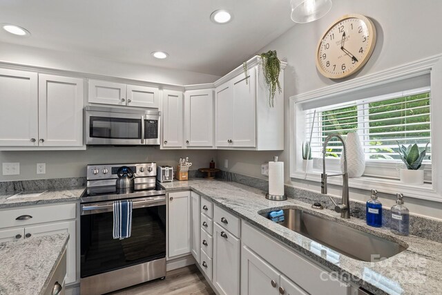 174 Ridge Rd, Lake Lure, NC 28746 - kitchen with appliances with stainless steel finishes, white cabinetry, recessed lighting, light wood-style flooring, and light stone countertops