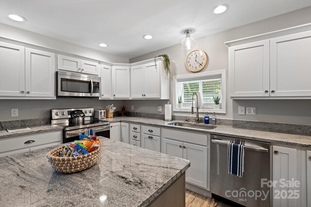 174 Ridge Rd, Lake Lure, NC 28746 - kitchen with appliances with stainless steel finishes, white cabinets, recessed lighting, light stone countertops, and light wood-type flooring