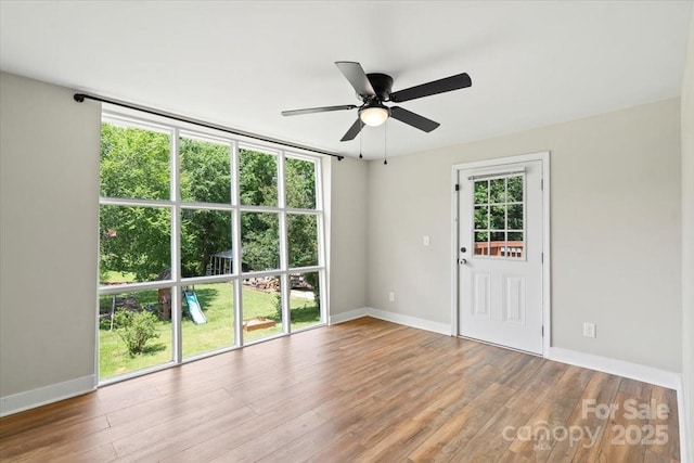 321 E Taylor St, Landis, NC 28088 - empty room with wood finished floors, a ceiling fan, and baseboards
