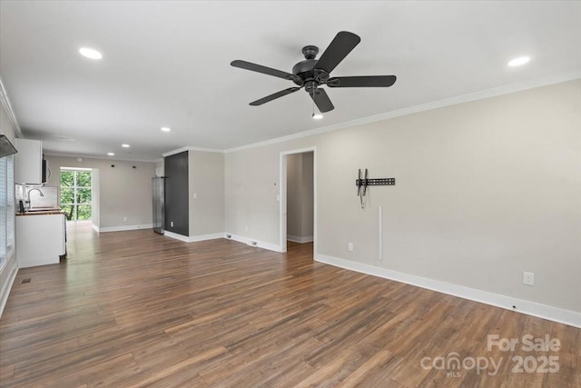 321 E Taylor St, Landis, NC 28088 - unfurnished living room with a sink, recessed lighting, baseboards, dark wood-style flooring, and crown molding