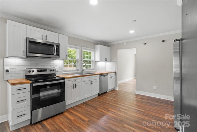 321 E Taylor St, Landis, NC 28088 - kitchen featuring wood counters, stainless steel appliances, a sink, decorative backsplash, and ornamental molding