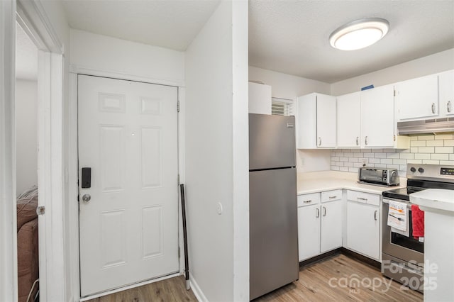 1602 Eagles Pl Unit J103, Rock Hill, SC 29732 - kitchen with appliances with stainless steel finishes, under cabinet range hood, light wood finished floors, white cabinets, and light countertops