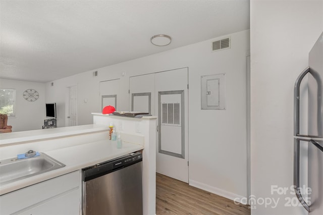 1602 Eagles Pl Unit J103, Rock Hill, SC 29732 - kitchen with appliances with stainless steel finishes, light wood-style flooring, electric panel, light countertops, and white cabinetry
