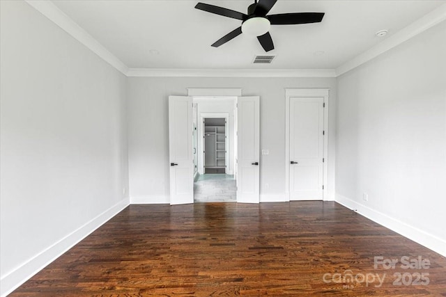 115 Augusta Ln, Shelby, NC 28150 - unfurnished bedroom with wood finished floors, baseboards, crown molding, a ceiling fan, and a walk in closet