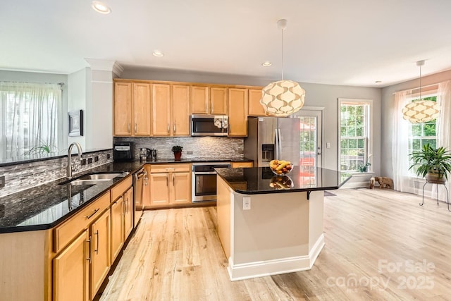 5832 Lagrande Dr, Charlotte, NC 28269 - kitchen with appliances with stainless steel finishes, a sink, light wood finished floors, decorative backsplash, and pendant lighting