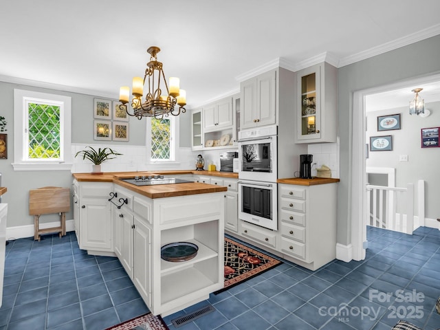287 Pacolet Ridge Ln, Tryon, NC 28782 - kitchen with butcher block countertops, open shelves, a chandelier, white double oven, and crown molding