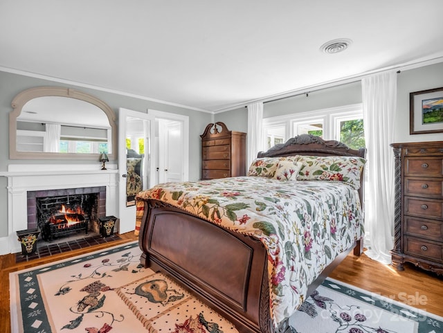 287 Pacolet Ridge Ln, Tryon, NC 28782 - bedroom featuring wood finished floors, multiple windows, a tile fireplace, and crown molding