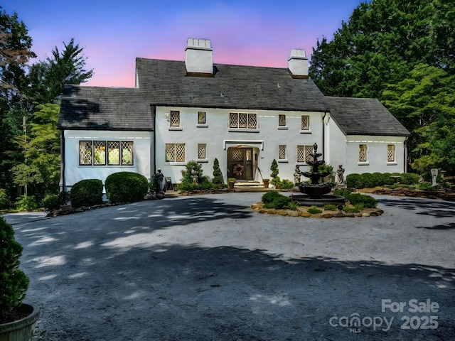 287 Pacolet Ridge Ln, Tryon, NC 28782 - tudor-style house with a chimney, curved driveway, and stucco siding