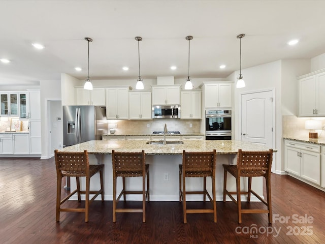 8035 Pastime Ln, Clover, SC 29710 - kitchen with appliances with stainless steel finishes, decorative backsplash, white cabinetry, a large island with sink, and dark wood-style flooring