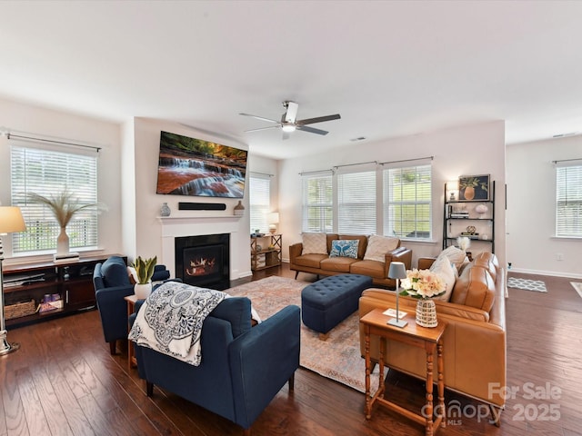 8035 Pastime Ln, Clover, SC 29710 - living area featuring ceiling fan, dark wood-style floors, and a warm lit fireplace