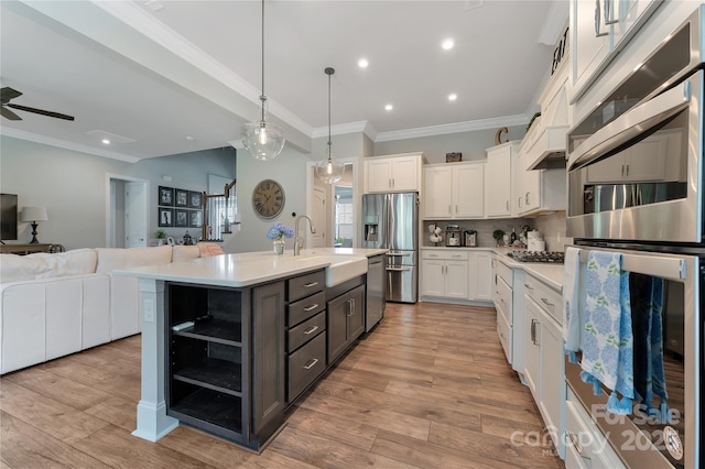 11313 Limehurst Pl, Charlotte, NC 28278 - kitchen featuring stainless steel appliances, open floor plan, ornamental molding, white cabinetry, and light countertops