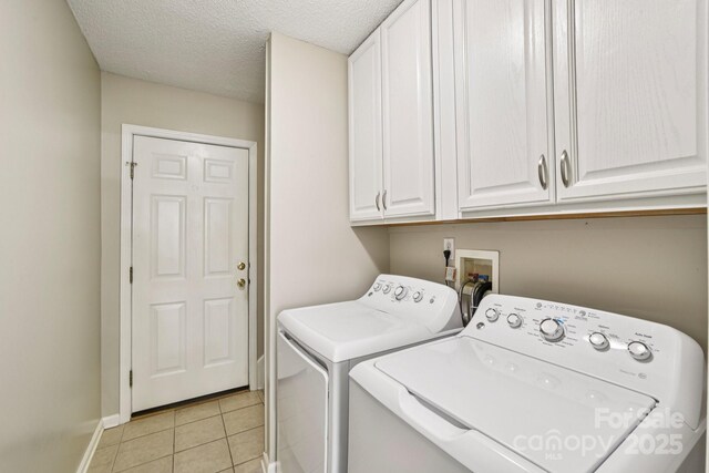 343 Stonehollow Rd, Fletcher, NC 28732 - washroom with cabinet space, washer and dryer, a textured ceiling, and light tile patterned flooring