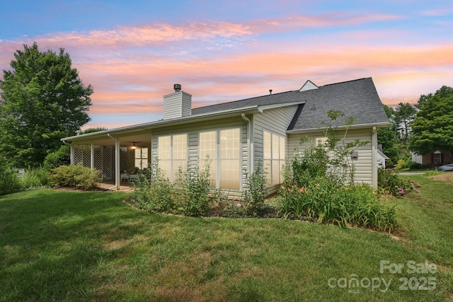 343 Stonehollow Rd, Fletcher, NC 28732 - back of property at dusk featuring a yard, a chimney, and roof with shingles