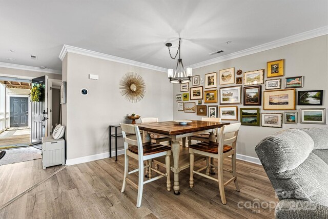 860 Jetton St Unit 59, Davidson, NC 28036 - dining space featuring wood finished floors, a chandelier, and crown molding