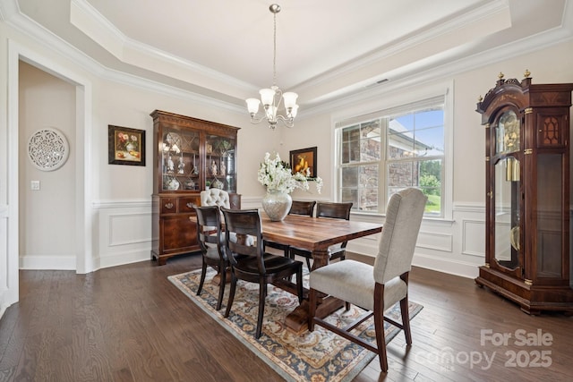 12410 Franklin Park Ln, Huntersville, NC 28078 - dining area featuring a raised ceiling, a chandelier, dark wood finished floors, ornamental molding, and a decorative wall