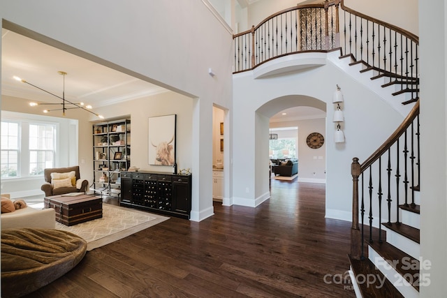 15103 Cimarron Hills Ln, Charlotte, NC 28278 - foyer entrance with arched walkways, dark wood-style floors, crown molding, stairway, and a chandelier