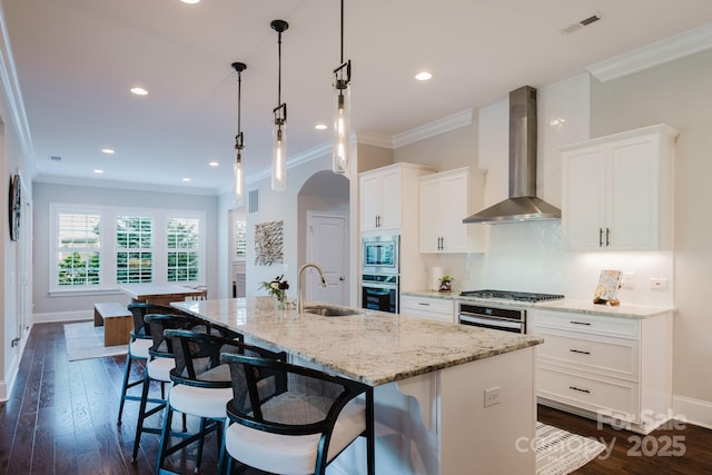 15103 Cimarron Hills Ln, Charlotte, NC 28278 - kitchen with stainless steel appliances, wall chimney exhaust hood, a sink, crown molding, and an island with sink