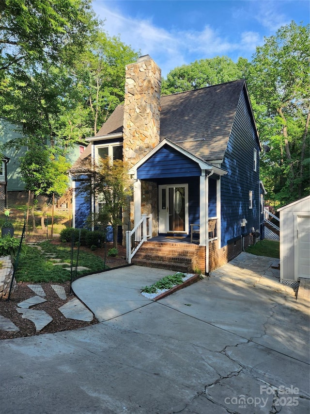 27092 Village Dr, Tega Cay, SC 29708 - view of front of house with a porch, roof with shingles, and a chimney