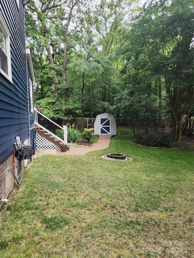 27092 Village Dr, Tega Cay, SC 29708 - view of grassy yard with a storage unit, a fire pit, and stairway