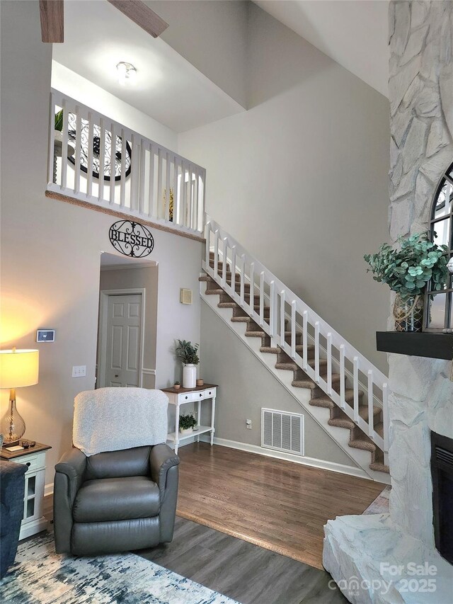 27092 Village Dr, Tega Cay, SC 29708 - living area with a high ceiling, stairway, wood finished floors, and a stone fireplace