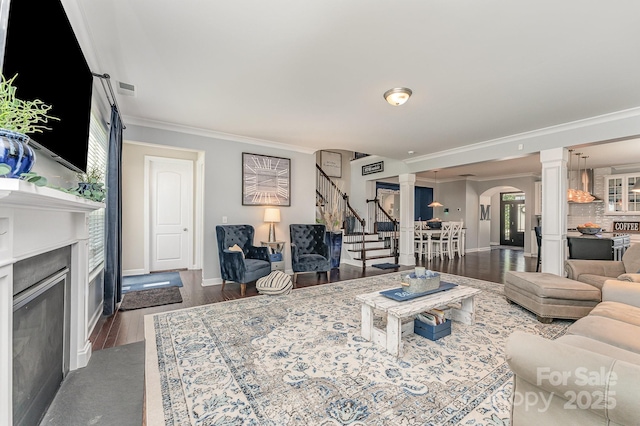 2606 Cheverny Pl, Concord, NC 28027 - living area with ornate columns, stairway, ornamental molding, a glass covered fireplace, and arched walkways