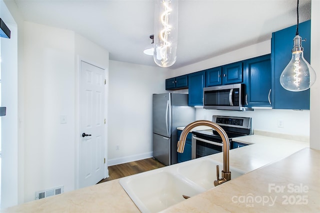 234 Wash Creek Dr Unit B, Hendersonville, NC 28739 - kitchen with appliances with stainless steel finishes, blue cabinetry, dark wood-type flooring, light countertops, and hanging light fixtures