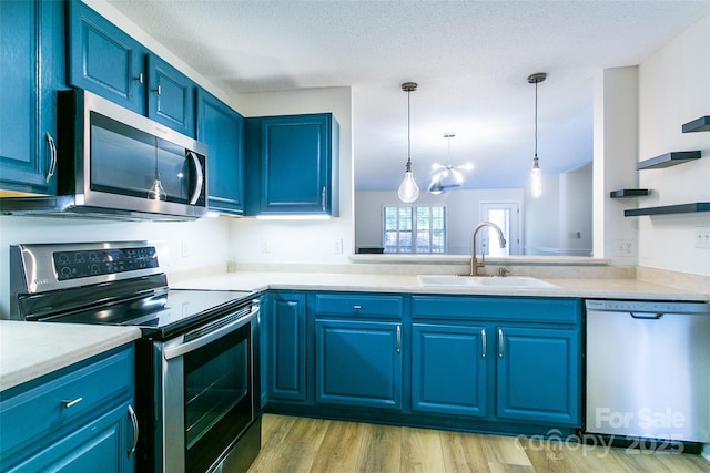 234 Wash Creek Dr Unit B, Hendersonville, NC 28739 - kitchen featuring stainless steel appliances, blue cabinetry, light countertops, light wood-type flooring, and a textured ceiling
