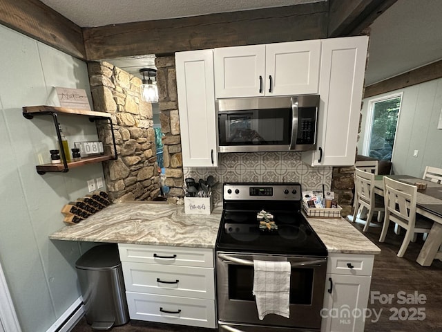 630 Shumont Rd, Black Mountain, NC 28711 - kitchen featuring appliances with stainless steel finishes, white cabinetry, light stone countertops, and a textured ceiling