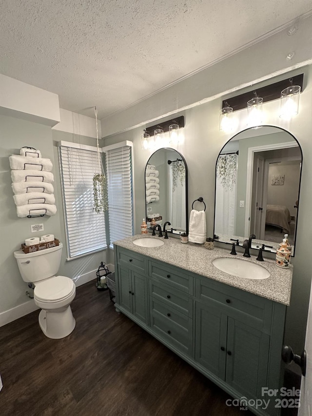 630 Shumont Rd, Black Mountain, NC 28711 - ensuite bathroom with wood finished floors, a textured ceiling, toilet, double vanity, and baseboards