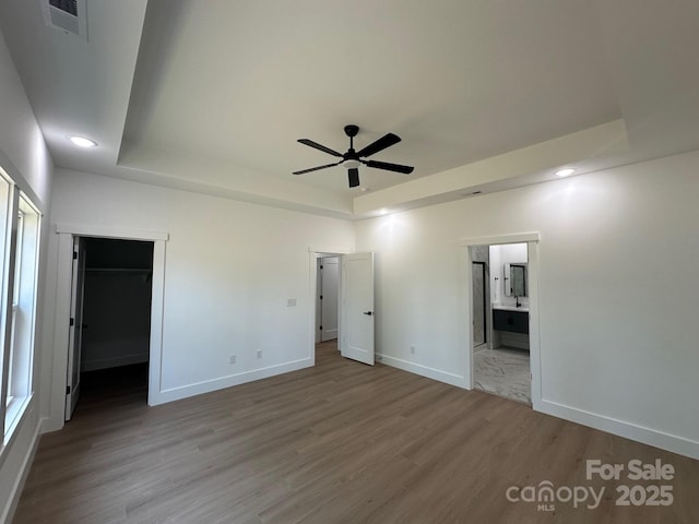953 Mike Cir, Spartanburg, SC 29303 - unfurnished bedroom featuring a raised ceiling, wood finished floors, baseboards, recessed lighting, and ensuite bath