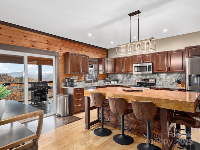 110 Garden Knoll Rd, Franklin, NC 28734 - kitchen featuring stainless steel appliances, backsplash, a kitchen bar, pendant lighting, and light wood-type flooring