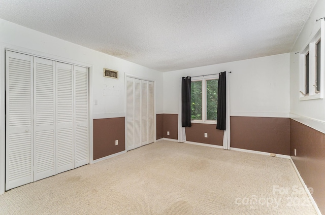 110 Hidden Valley St, Cherryville, NC 28021 - unfurnished bedroom with multiple closets, a textured ceiling, and carpet floors