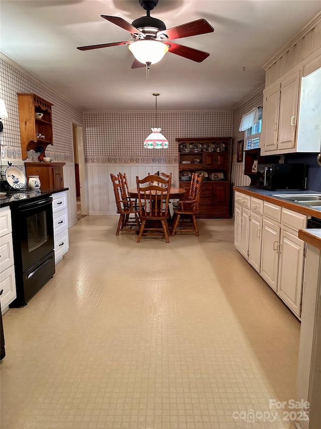 211 S Slack St, Albemarle, NC 28001 - kitchen featuring black appliances, dark countertops, wallpapered walls, ceiling fan, and white cabinets