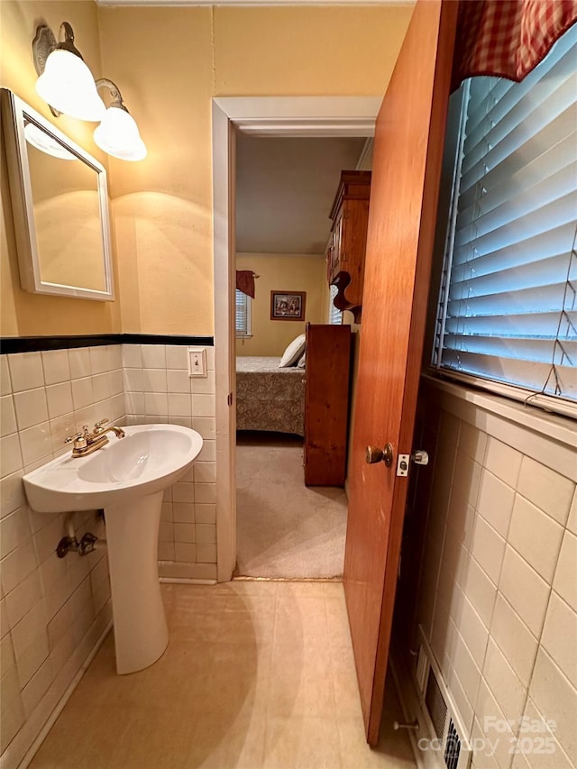 211 S Slack St, Albemarle, NC 28001 - ensuite bathroom with tile walls, tile patterned flooring, and a wainscoted wall