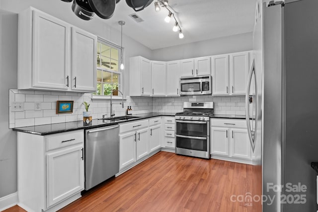 8700 Fox Tail Ln, Huntersville, NC 28078 - kitchen with appliances with stainless steel finishes, dark countertops, and white cabinetry