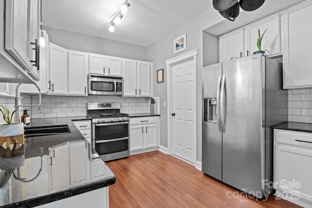 8700 Fox Tail Ln, Huntersville, NC 28078 - kitchen with stainless steel appliances, decorative backsplash, white cabinetry, and light wood-style floors