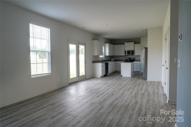 69 Ravibha Ct, Clayton, NC 27520 - kitchen featuring stainless steel appliances, open floor plan, light wood finished floors, and white cabinets
