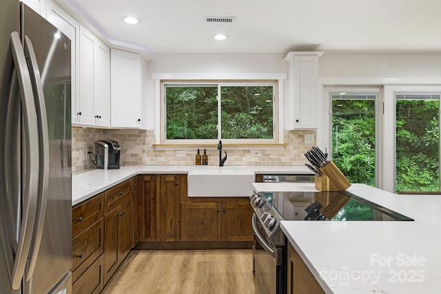 487 Duncan Creek Rd, Fletcher, NC 28732 - kitchen featuring appliances with stainless steel finishes, decorative backsplash, light wood-style floors, white cabinetry, and recessed lighting