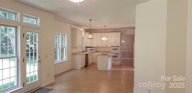 12314 Chickasaw Dr, Huntersville, NC 28078 - kitchen with white appliances, light wood-style floors, ceiling fan, white cabinets, and a kitchen island