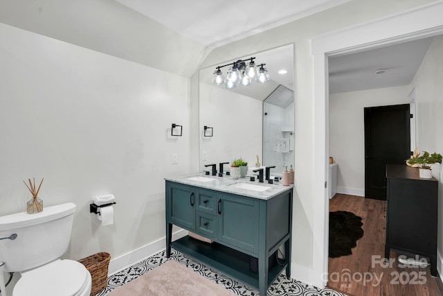 316 Wade Hampton Dr, Matthews, NC 28104 - full bath with baseboards, double vanity, toilet, vaulted ceiling, and wood finished floors