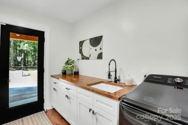 316 Wade Hampton Dr, Matthews, NC 28104 - kitchen featuring a sink, washer / clothes dryer, wood counters, white cabinets, and wood finished floors