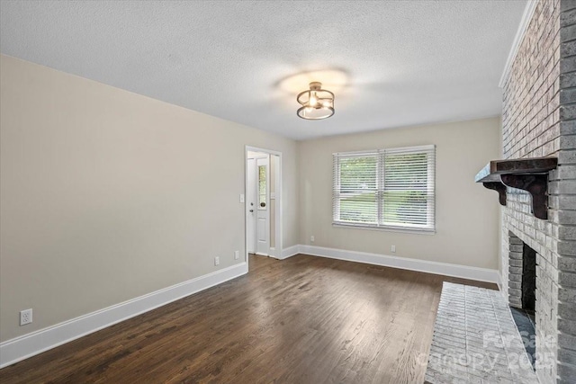 5811 Gettysburg Dr, Concord, NC 28027 - unfurnished living room with a brick fireplace, dark wood-style floors, and a textured ceiling