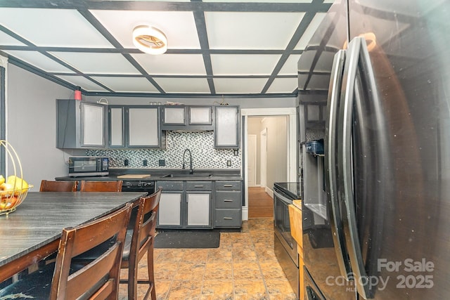 300 S Hudson Ave, Spencer, NC 28159 - kitchen with stainless steel appliances, gray cabinets, dark countertops, decorative backsplash, and light stone finish floors