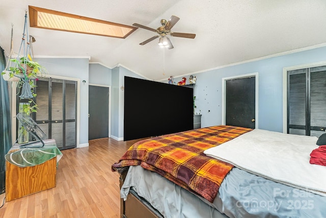 300 S Hudson Ave, Spencer, NC 28159 - bedroom featuring wood finished floors, vaulted ceiling, a skylight, ornamental molding, and two closets